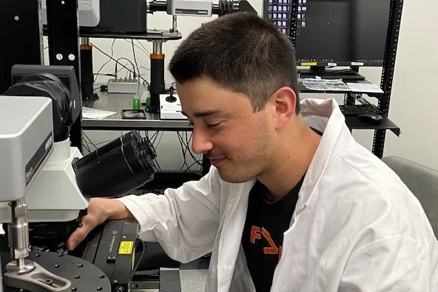 A lab researcher is setting up a microscope.